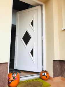 two pumpkins sitting in front of a white door at Kókusz Apartmanok in Eger