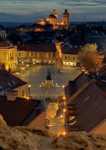 a view of a city at night with lights at Kókusz Apartmanok in Eger