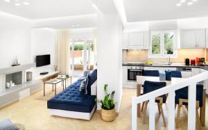 cocina y sala de estar con sofá azul y mesa en Kassandra Villas en Hanioti