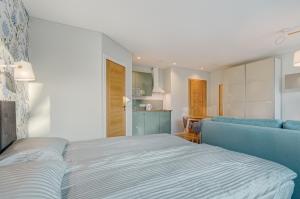 1 dormitorio con 1 cama y 1 sofá azul en City Studio 1A - Courtyard View, en Vilna