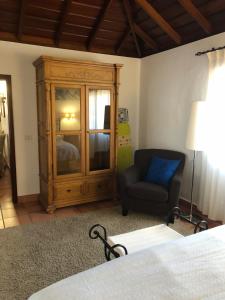 a living room with a chair and a cabinet at Casa rural Los Llanos Negros in Fuencaliente de la Palma