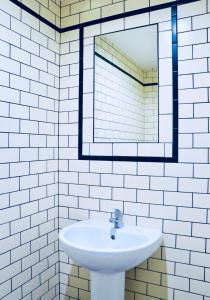 a white bathroom with a sink and a mirror at The Liverpool Pod Travel Hostel in Liverpool