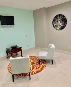 a living room with chairs and a table and a television at HomeStay Inn & Suites Edinburg in Edinburg