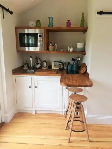 eine Küche mit einer Theke mit einer Spüle und einer Mikrowelle in der Unterkunft The Parcel Shed in Gilling East