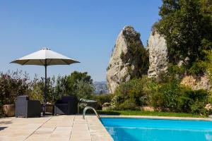 a patio with an umbrella and a swimming pool at Villa Manon in Auriol