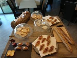 a table topped with different types of bread and pastries at The Originals City, Hôtel des Arts, Montauban (Inter-Hotel) in Nègrepelisse