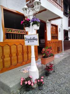 Światło uliczne z kwiatami i znakiem na nim w obiekcie Elizabetha Hostal w mieście Salento