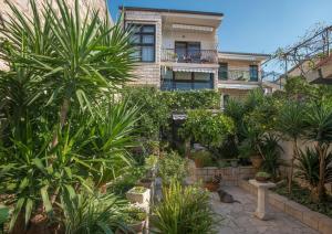 un chat dans un jardin en face d'un bâtiment dans l'établissement Apartments Bose, à Makarska