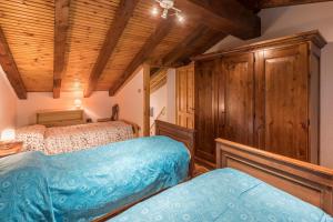 een slaapkamer met 2 bedden en een houten plafond bij Maison Courthoud Alloggio ad uso turistico - VDA - RHÊMES-SAINT-GEORGES n 0002 in Rhemes-Saint-Georges