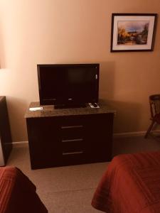 a bedroom with a television and a bed at Hotel Terrace in Millinocket