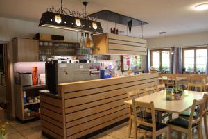 a restaurant with a counter and a table and chairs at Hotel Urirotstock in Isenthal