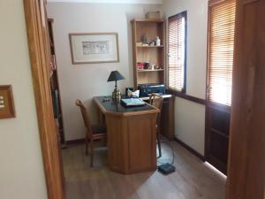 a room with a desk with a lamp and a chair at Hermosa Casa Cerca de Todo in Rosario