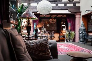 a living room with a chair and a lamp at Hôtel des Deux Clefs in Turckheim