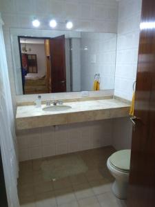 a bathroom with a sink and a toilet and a mirror at Hermosa Casa Cerca de Todo in Rosario +14 photos