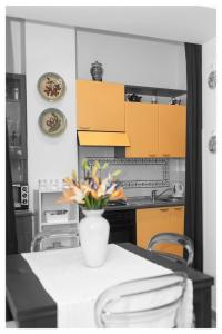 Insidesalernohome في ساليرنو: مطبخ مع دواليب صفراء وطاولة مع ورد