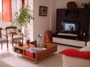 a living room with a couch and a tv at Pituba quartos in Salvador