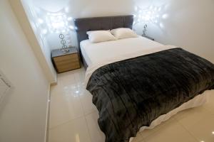 sypialnia z dużym łóżkiem z czarnym kocem w obiekcie White Lux Apartment For 2 VIPGreece w Atenach