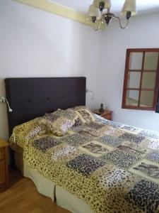 a bedroom with a bed with a black and white comforter at Hermosa Casa Cerca de Todo in Rosario