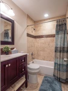 Un baño con inodoro, bañera y lavabo. en Verandas at Uptown, en Austin
