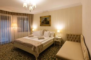 a hotel room with a bed and a couch at Ave, Alba! in Alba Iulia