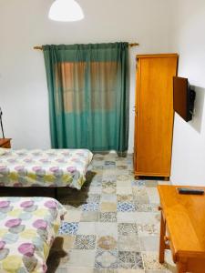 Cette chambre comprend 2 lits, une table et une armoire. dans l'établissement Efigenia playa/mar 1, à Valle Gran Rey