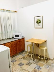 a kitchen with a wooden table and two stools at Efigenia playa/mar 1 in Valle Gran Rey