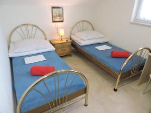 two beds in a room with two red pillows at Noclegi Mączyńskiego in Jarosław