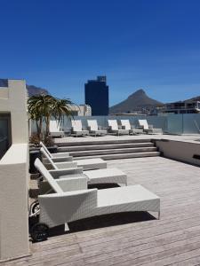 a row of white chairs on the roof of a building at Harbour Bridge Suite 220 in Cape Town