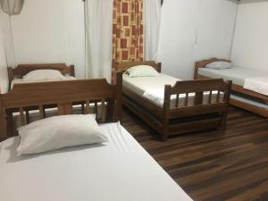 een kamer met drie bedden in een kamer bij Hostel Orozco - Costa Rica in Río Cuarto