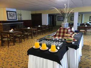 una mesa con platos de comida y zumo de naranja en Hotel Cabo Santa Maria en La Paloma