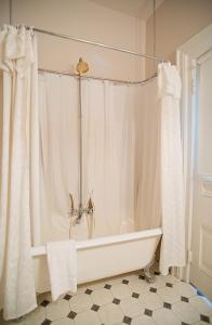 a bathroom with a tub and a shower curtain at Amethyst Inn in Victoria