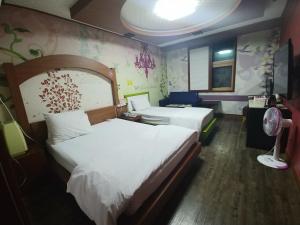 Habitación de hotel con 2 camas y TV en New Grand Hotel en Daegu