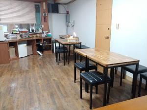 a kitchen with wooden tables and chairs in a room at New Grand Hotel in Daegu