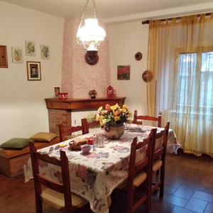 einen Esstisch mit einer Blumenvase darauf in der Unterkunft Casa del Ciliegio in Radicofani