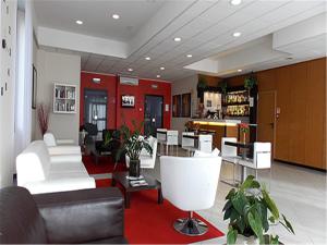 a living room with white furniture and a bar at Hotel David in Sesto Calende