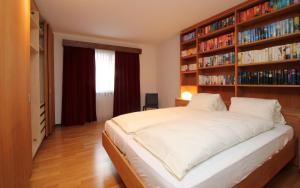 een slaapkamer met een groot bed en boekenplanken bij Chesa Alice in St. Moritz