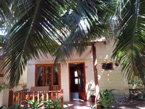 a house with a palm tree in front of it at Free Beach Resort in Phú Quốc