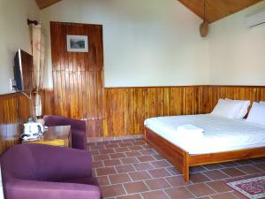 a bedroom with a bed and a purple couch at Free Beach Resort in Phú Quốc