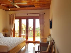 a bedroom with a bed and a sliding glass door at Free Beach Resort in Phú Quốc