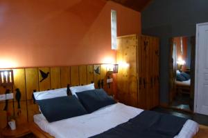 Schlafzimmer mit einem großen Bett mit einem Kopfteil aus Holz in der Unterkunft SOUIMANGA-HOTEL in Antsirabe