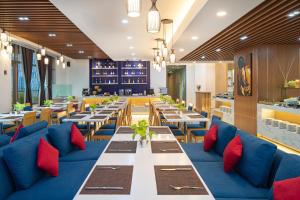 a dining room with tables and blue couches at Ibis Saigon South in Ho Chi Minh City