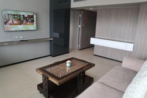 a living room filled with furniture and a tv at Pearl Hotel - SHA Plus in Phuket