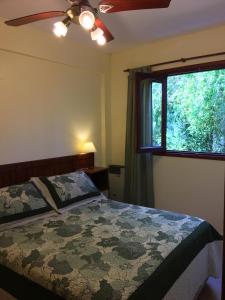 a bedroom with a bed and a ceiling fan and a window at Posada Las Dunas in San Bernardo