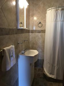 a bathroom with a sink and a shower curtain at Posada Las Dunas in San Bernardo