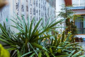 a plant in front of a wall with writing on it at Zhangjiajie Tingyutang Little Yard in Zhangjiajie
