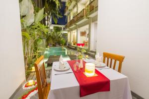 烏布的住宿－畢瑪烏瑪拉旅館，一间带红色桌布的餐桌的用餐室