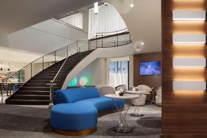 - un hall avec un canapé bleu et un escalier dans l'établissement Hyatt Regency Los Angeles International Airport, à Los Angeles