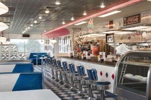 a restaurant with blue chairs and a counter and a bar at Travelodge by Wyndham Missouri Valley in Missouri Valley