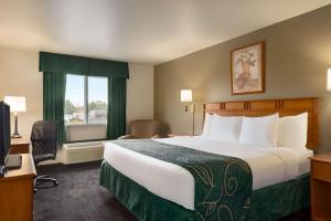 a hotel room with a large bed and a window at Travelodge by Wyndham Missouri Valley in Missouri Valley +19 photos