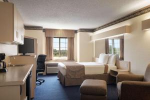 a large hotel room with a bed and a kitchen at Travelodge by Wyndham Fort Scott in Fort Scott